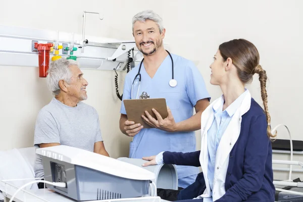 Fisioterapeuta masculino con colega y paciente en el centro de rehabilitación — Foto de Stock