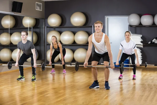 Aktivních mužů a žen, Barbells zvedání v tělocvičně — Stock fotografie