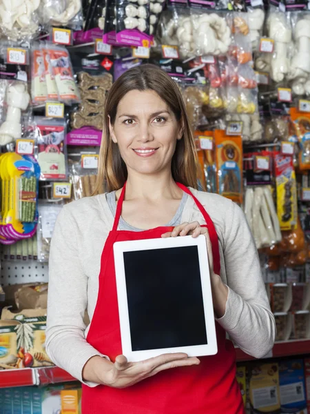 Улыбающаяся продавщица показывает цифровые планшеты в зоомагазине — стоковое фото