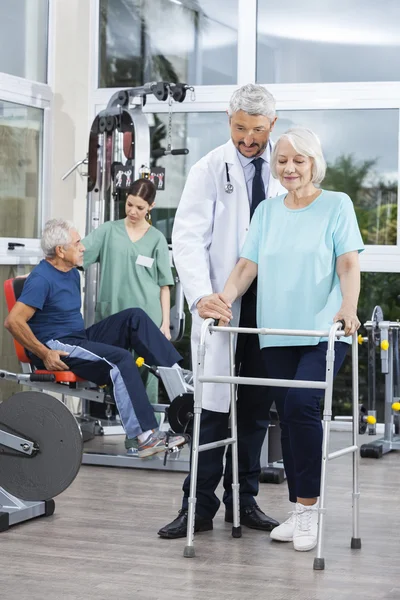 Fysiotherapeut helpen vrouw met Walker In Fitness Center — Stockfoto