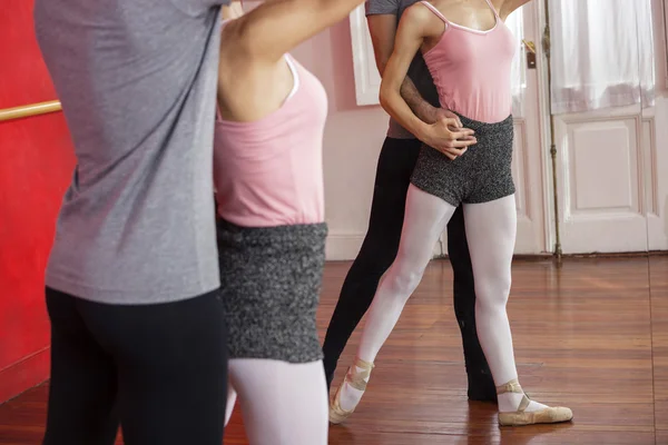 Midsection utbildaren hjälper balettdansös — Stockfoto