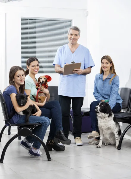 Infermiera e proprietari con animali domestici in cliniche in attesa Area — Foto Stock