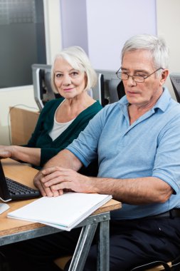 Erkek sınıf arkadaşı tarafından bilgisayar sınıf sırasında oturan kadın kıdemli