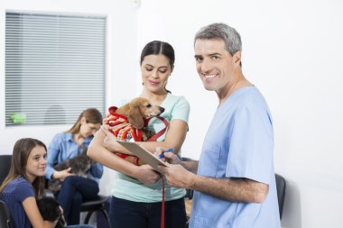 Hemşire yazma panosuna kadın taşıyan Dachshund süre