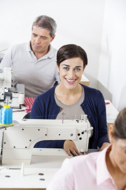 Fabrikada çalışmanın meslektaşları ile kendinden emin terzi