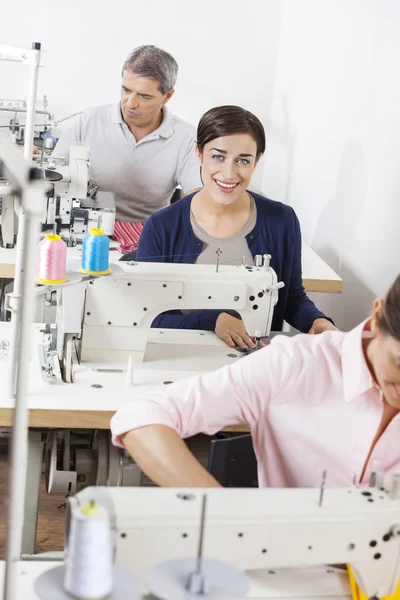 Retrato de alfaiate feliz com colegas que trabalham na fábrica — Fotografia de Stock