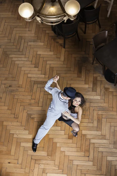 Ženské Tango tanečník účinkoval s mužem na dřevěnou podlahu — Stock fotografie