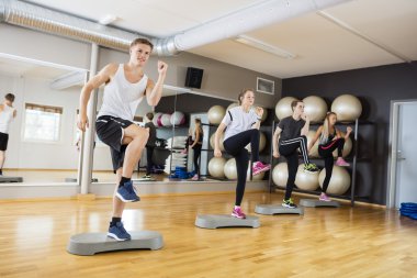 Aktif erkek ve kadın adım egzersiz spor salonunda gerçekleştirme