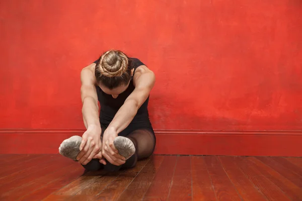 Ballet danseuse étirant ses jambes en studio de danse — Photo