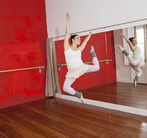 Bailarina saltando mientras se realiza en el estudio de danza — Foto de Stock