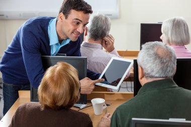 CIA içinde son sınıf öğrencileri için dijital Tablet gösteren gülümseyen öğretmen