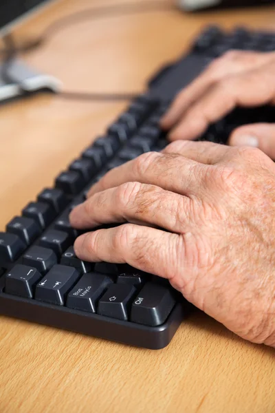 Estudante sênior usando teclado na sala de aula — Fotografia de Stock