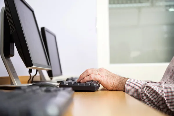 Uomo anziano utilizzando il computer in aula — Foto Stock