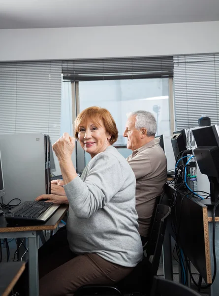 Старшая женщина аплодирует в классе компьютеров — стоковое фото