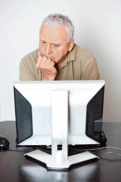 Hombre mayor serio mirando monitor de computadora en clase — Foto de Stock