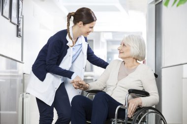 Tekerlekli sandalyede oturan kadın kıdemli teselli fizyoterapist