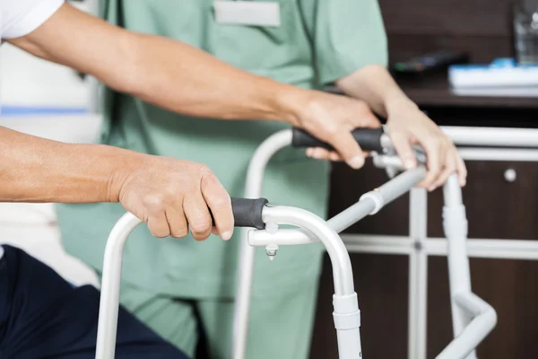 Pacientes sosteniendo manos Walker por enfermera en centro de rehabilitación —  Fotos de Stock