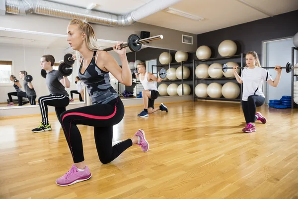 Jeunes amis levant des cloches dans la salle de gym — Photo