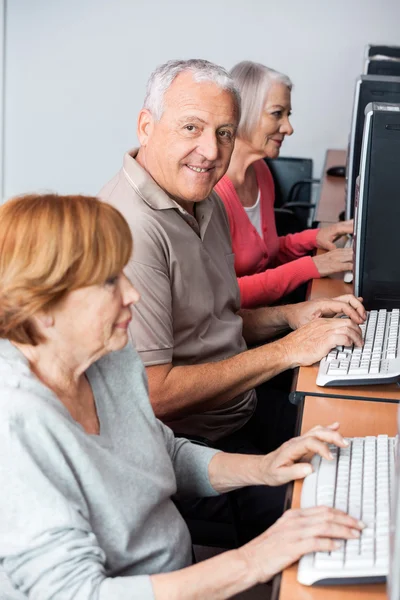 Szczęśliwy człowiek starszy za pomocą komputera w klasie — Zdjęcie stockowe