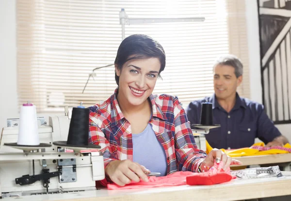 Trabajador feliz sentado en el banco de trabajo en la fábrica de costura — Foto de Stock