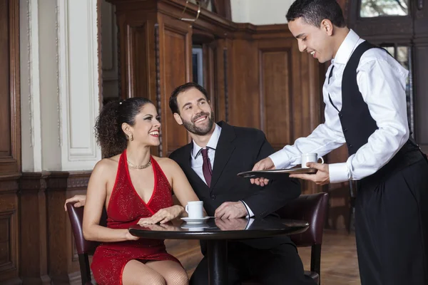 Boldog pincér szolgáló kávé Tango pár étterem — Stock Fotó