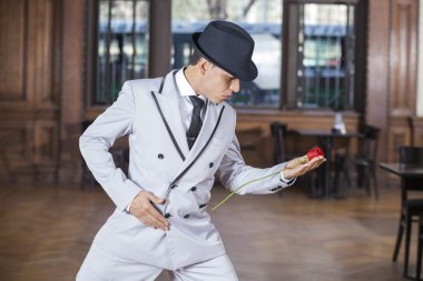 Tango dansçısı yaparken taze gül tutan