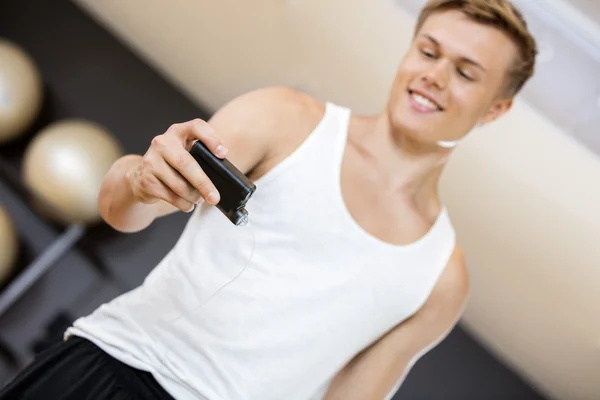 Joven sosteniendo monitor de glucosa en el gimnasio — Foto de Stock