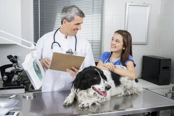 Medico holding appunti mentre guardando ragazza con confine colli — Foto Stock