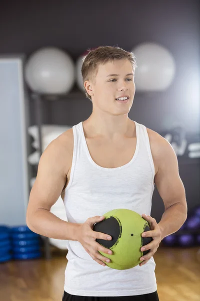 Mann hält Medizinball in Fitnessstudio — Stockfoto