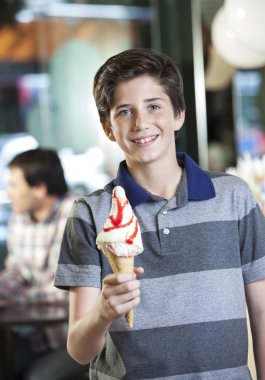 Mutlu çocuk gösteren vanilyalı dondurma salonu