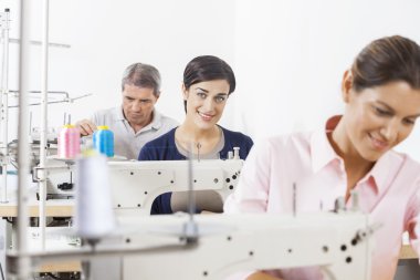 Fabrikada çalışmanın meslektaşları ile mutlu terzi