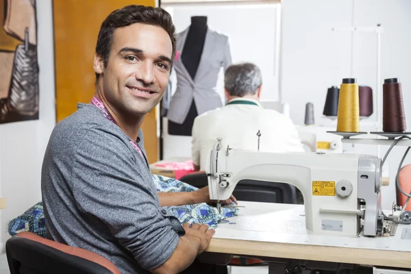 微笑男裁缝用缝纫机的肖像 — 图库照片