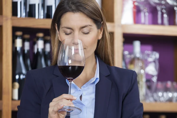 Client sentant le vin rouge dans la boutique — Photo