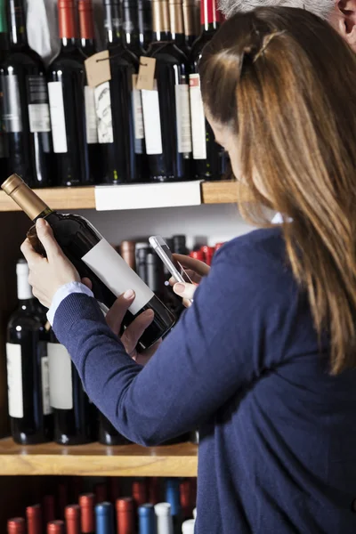 Couple Scanning code-barres sur bouteille de vin à travers Smartphone — Photo