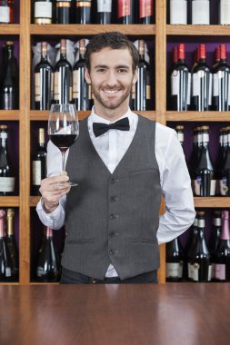 Kırmızı şarap cam tezgahta tutan barmen