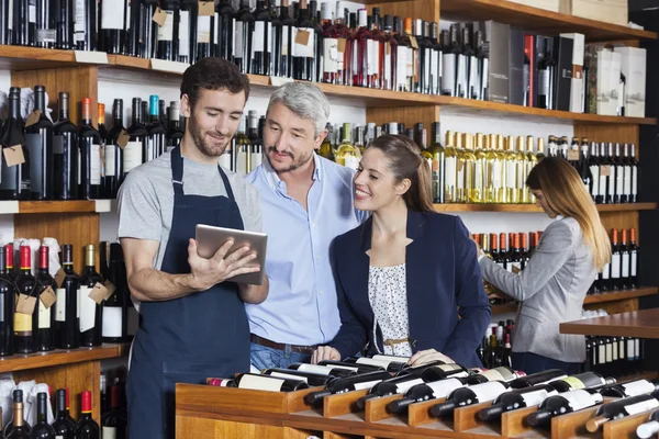 Verkoper wijn informatie tonen aan klanten op Tablet Compute — Stockfoto