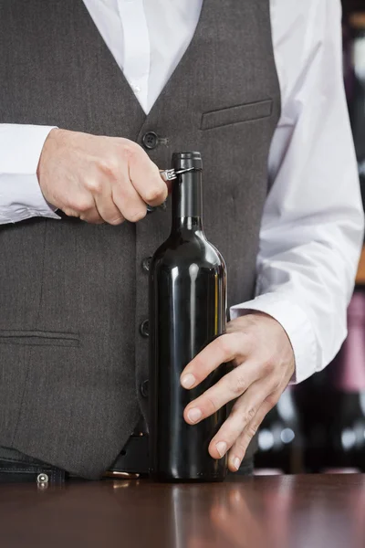Şarap şişe açılış barmen midsection — Stok fotoğraf