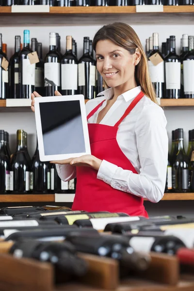 Vendedora mostrando computador tablet em branco na adega — Fotografia de Stock