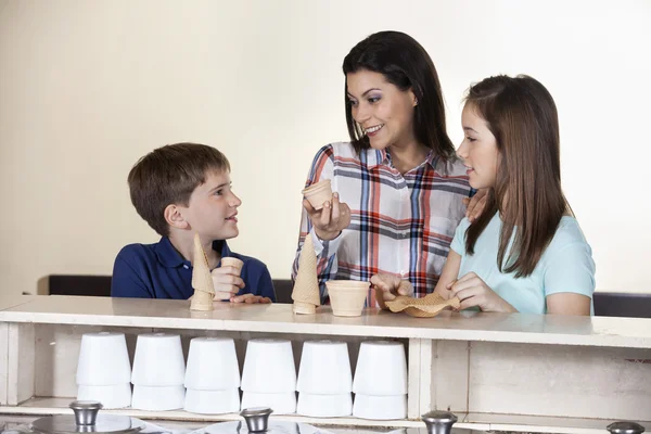 Familjen att välja mellan koner och koppar vid disken — Stockfoto