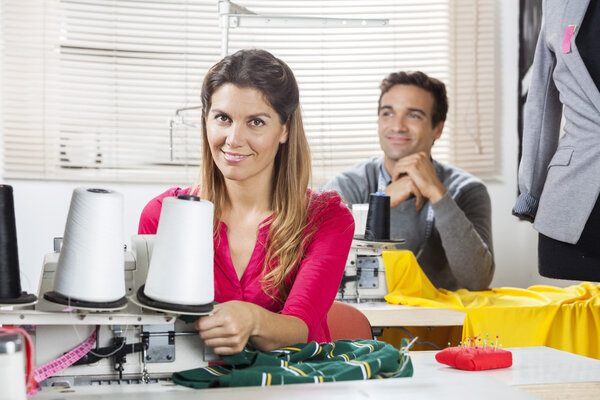 Smiling Worker Sitting At Workbench In Sewing Factory
