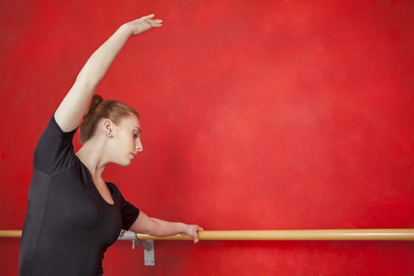 Bailarina practicando sus movimientos de baile en la barra — Foto de Stock