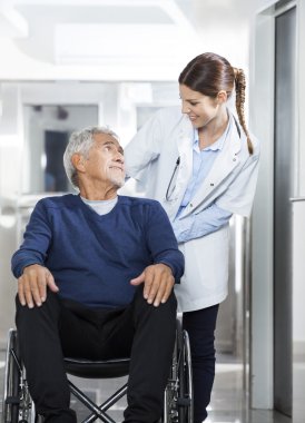 Doktor üst düzey hasta tekerlekli sandalye üzerinde seyir