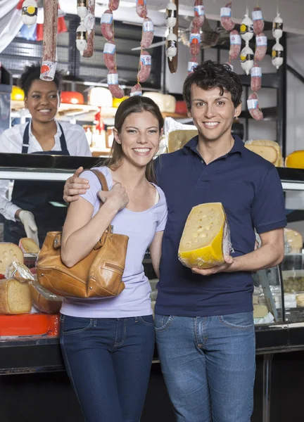 Glückliches junges Paar hält Käse im Supermarkt — Stockfoto