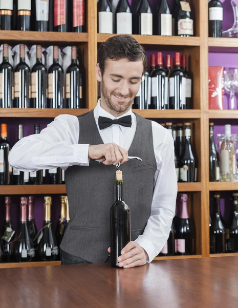 Leende Bartender öppna vinflaska — Stockfoto