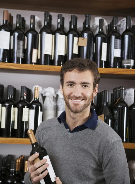 Cliente feliz segurando garrafa de vinho no supermercado — Fotografia de Stock