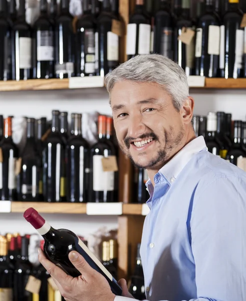 Nöjd manliga kund håller vinflaska i stormarknad — Stockfoto