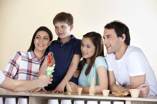 Família olhando garçom dando sorvete no balcão — Fotografia de Stock