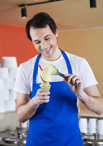 Garçom sorridente preparando sorvete de baunilha — Fotografia de Stock