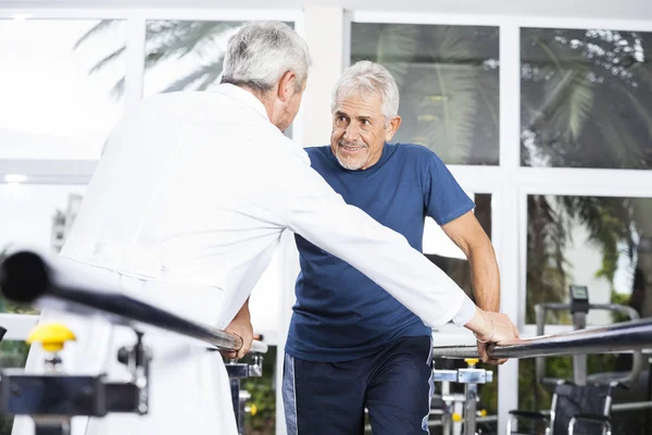 Hombre mayor mirando al médico mientras camina en el estudio de fitness — Foto de Stock