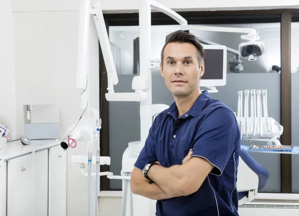 Dentista confiante com braços cruzados na clínica — Fotografia de Stock